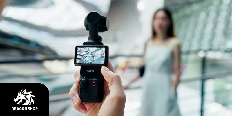 خرید اینترنتی دوربین گیمبال اسمو پاکت DJI Osmo Pocket 3
<h2 style="text-align: justify;">ویژگی‌های دوربین گیمبال اسمو پاکت DJI Osmo Pocket 3</h2>
<h3 style="text-align: justify;">1- امکانات پیشرفته برای فیلمبرداری و عکاسی حرفه‌ای</h3>
<p style="text-align: justify;">با دوربین گیمبال اسمو پاکت DJI Osmo Pocket 3 می‌توانید با کیفیت 4K و سرعت 120 فریم در ثانیه فیلمبرداری کنید و به‌لطف این کیفیت بالا تصاویری دقیق با تمامی جزئیات را ضبط خواهید کرد. علاوه‌براین به‌لطف سنسور یک اینچی CMOS می‌توانید تصاویری باکیفیت و شفاف با جزئیات دقیق و سایه‌روشن‌های حرفه‌ای بگیرید.</p>
<p style="text-align: justify;">هنگام استفاده از این دوربین - چه برای استریم زنده و چه برای ساخت ویدئوهای تبلیغاتی یا موارد مشابه - می‌توانید با تکیه بر فوکوس خودکار دوربین روی سوژه اطمینان داشته باشید که همیشه سوژه‌ی اصلی در مرکز تصویر است، حتی اگر حرکاتی سریع داشته باشد و زیاد جابه‌جا شود. دوربین می‌تواند به‌صورت خودکار سوژه را تشخیص دهد و با حرکاتی آرام و طبیعی روی آن ثابت باقی بماند.</p>
<p style="text-align: justify;">البته شما می‌توانید خودتان هم با قابلیت 4x digital zoom روی سوژه زوم کرده و تصاویر واضح‌تری از سوژه‌هایی که از شما دور هستند تهیه کنید.</p>
<img class="aligncenter size-full wp-image-267353" src="http://dragon-shop.ir/wp-content/uploads/2024/07/خرید-گیمبال-DJI-Osmo-Pocket-3-Camera-Copy.jpg" alt="دوربین گیمبال اسمو پاکت DJI Osmo Pocket 3" width="800" height="450" />
<p style="text-align: justify;">مزیت دیگر دوربین گیمبال اسمو پاکت DJI Osmo Pocket 3 که به فیلمبرداری باکیفیت‌تر کمک قابل‌توجهی می‌کند، طراحی آن و استفاده از تثبیت‌کننده‌ی مکانیکی سه‌محوره برای جلوگیری از لرزش تصویر ناشی از لرزش دست حتی در حرکات شدید و سریع دوربین است. این تثبیت‌کننده لرزش‌های تصویر را حذف می‌کند و به‌این‌ترتیب باعث می‌شود حتی در حالت‌های اکشن هم تصاویری یکنواخت و بدون لرزش داشته باشید.</p>
<p style="text-align: justify;">حین استفاده از دوربین می‌توانید از یکی از 3 حالت رنگی یعنی D-Log M، 10-bit و HLG HDR استفاده کنید. در دو حالت اول دوربین می‌تواند تا یک میلیارد رنگ را ثبت کند و بنابراین این حالت‌ها برای فیلمبرداری و عکاسی از سوژه‌هایی که شامل رنگ‌های مختلف و طیف رنگ گسترده‌ای هستند – مثلاً غروب آفتاب یا یک منظره‌ی رنگارنگ – بسیار مناسب است و می‌تواند جزئیات دقیق این سوژه‌ها را ثبت کند و تصاویری زنده و واقع‌گرایانه را در اختیارتان قرار دهد. حالت سوم همان‌طور که از نام‌اش پیداست فیلمبرداری با HLG 10 بیتی را ممکن می‌کند و به‌این‌ترتیب درصورتی‌که از دستگاه‌هایی که از HDR پشتیبانی می‌کنند برای تماشای تصاویر ضبط‌شده استفاده کنید، به‌شکل خودکار شاهد محدوده‌ی دینامیکی بالاتری خواهید بود.</p>
<img class="aligncenter size-full wp-image-267352" src="http://dragon-shop.ir/wp-content/uploads/2024/07/خرید-اینترنتی-DJI-Osmo-Pocket-3-Camera-Copy.jpg" alt="خرید دوربین گیمبال اسمو پاکت DJI Osmo Pocket 3" width="800" height="450" />
<p style="text-align: justify;">دوربین گیمبال اسمو پاکت 3 گذشته‌ازاین از ActiveTrack 6.0 پشتیبانی می‌کند. این قابلیت به شما در ضبط فیلم‌های حرفه‌ای‌تر کمک می‌کند بدون این‌که نیاز به تجهیزات پیشرفته و مهارت خاصی داشته باشید. ردیابی خودکار در این دوربین 3 حالت مختلف automatic face detection (تشخیص چهره‌ی خودکار)، simplified tracking (ردیابی ساده) و dynamic framing (قاب‌بندی دینامیک) دارد که می‌توانید با انتخاب هر کدام با توجه به حرکات سوژه، پس‌زمینه‌ی تصویر و هدف‌تان از فیلمبرداری بهترین ردیابی خودکار را داشته باشید.</p><h3 style="text-align: justify;">2- طراحی کاربردی و جمع‌وجور</h3>
<p style="text-align: justify;">طراحی دوربین گیمبال اسمو پاکت DJI Osmo Pocket 3 از مهم‌ترین نقاط قوت آن است. این دوربین به‌شکلی طراحی شده که بتوانید آن را به‌راحتی در جیب و کیف‌تان جای دهید و درنتیجه همیشه همراه‌تان یک دوربین حرفه‌ای برای عکاسی و فیلمبرداری داشته باشید.</p>
<p style="text-align: justify;">در این دوربین از یک نمایشگر لمسی 2 اینچی OLED استفاده شده که دسترسی به تنظیمات را بسیار آسان می‌کند و تصاویری که ضبط کرده‌اید را با کیفیت بسیار بالا و پوشش رنگ گسترده نمایش می‌دهد.</p>
<p style="text-align: justify;">چنان‌که در بالا اشاره شد، در این دوربین از تثبیت‌کننده‌ی سه‌محوره استفاده شده که هم باعث ثبات دوربین و حذف لرزش دست حتی در حرکت با سرعت‌ بالا می‌شود و هم چرخش دوربین را ممکن می‌کند. با چرخاندن دوربین می‌توانید قاب تصویر را با توجه به سوژه به‌حالت افقی یا عمودی درآورید و درضمن این امکان را دارید که حین فیلمبرداری دوربین را بچرخانید و حتی سرعت چرخش را از بین یکی از 3 گزینه‌ای که پیش رو دارید تعیین کنید. تثبیت‌کننده‌ی دوربین علاوه‌براین به‌شکلی طراحی شده که بعد از هر بار چرخش قفل شود تا حرکت بدنه باعث چرخش‌اش نشود و تنها زمانی تثبیت‌کننده امکان چرخش دوربین را می‌دهد که شما بخواهید.</p>
<img class="aligncenter size-full wp-image-267351" src="http://dragon-shop.ir/wp-content/uploads/2024/07/DJI-Osmo-Pocket-3-Camera-Copy-1.jpg" alt="خرید اینترنتی دوربین گیمبال اسمو پاکت DJI Osmo Pocket 3" width="800" height="450" />
<p style="text-align: justify;">تثبیت‌کننده‌ی دوربین علاوه بر تمامی این امکانات، امکان چرخش 180 درجه را با انتخاب گزینه‌ی Spinshot به شما می‌دهد که با استفاده از آن می‌توانید فیلم‌هایی حرفه‌ای‌تر و جذاب‌تر ضبط کنید و به‌ویژه از آن حین استریم برای تولید محتوای باکیفیت‌تر بهره ببرید.</p><h3 style="text-align: justify;">3- میکروفن داخلی با امکان ضبط صدای استریو</h3>
<p style="text-align: justify;">میکروفن داخلی دوربین گیمبال اسمو پاکت DJI Osmo Pocket 3 و عملکرد بسیار خوب‌اش در ضبط صداها مزیت دیگر این محصول است. این میکروفن می‌تواند صداها را به‌صورت همه‌جهته ضبط کند و از آن‌جا که قدرت تشخیص منبع اصلی صدا حتی در محیط‌های شلوغ و پر سروصدا را دارد، تحت هر شرایطی صدایی باکیفیت و استریو را در اختیارتان قرار می‌دهد. این میکروفن دارای فیلتر مخصوص برای حذف نویز ناشی از صدای باد است و بنابراین درصورت استفاده از آن در فضاهای باز با مشکل ضبط صدای هوا و وزش باد مواجه نخواهید بود.</p>
<p style="text-align: justify;">نکته‌ی قابل‌توجه دیگر درباره‌ی میکروفن این دستگاه سازگاری آن با DJI Mic 2 است. با اتصال این میکروفن به دوربین از طریق وای‌فای یا بلوتوث می‌توانید حین ضبط استریم، پادکست‌های دونفره یا مصاحبه‌ها صدایی شفاف‌تر و واضح‌تر داشته باشید.</p>
<p style="text-align: justify;"><img class="aligncenter size-full wp-image-267354" src="http://dragon-shop.ir/wp-content/uploads/2024/07/قیمت-گیمبال-DJI-Osmo-Pocket-3-Camera-Copy.jpg" alt="دوربین گیمبال اسمو پاکت DJI Osmo Pocket 3" width="720" height="480" /></p><h3 style="text-align: justify;">4- باتری داخلی با شارژدهی طولانی‌مدت</h3>
<p style="text-align: justify;">باتری داخلی دوربین گیمبال اسمو پاکت DJI Osmo Pocket 3 که از طریق کابل USB و پورت مخصوصی که روی بدنه‌ی دستگاه قرار داده شده شارژ می‌شود، با هر بار شارژ کامل حداکثر تا 166 دقیقه شارژدهی دارد. این باتری درصورت فیلمبرداری با کیفیت 4K و سرعت 60 فریم در ثانیه 116 دقیقه شارژدهی دارد و چنان‌چه با کیفیت 1080p و سرعت 24 فریم در ثانیه فیلمبرداری کنید، می‌توانید تا 166 دقیقه بدون نیاز به شارژ مجدد باتری از دوربین استفاده کنید.</p>
<p style="text-align: justify;">درضمن باتری این دوربین تنها در 16 دقیقه تا 80 درصد شارژ می‌شود و با این میزان شارژ می‌توانید تا 2 ساعت با آن فیلمبرداری کنید. به‌این‌ترتیب می‌توانید بدون نگرانی از خالی‌بودن باتری و با تکیه بر سرعت بسیار زیاد شارژ آن، همیشه دوربین را برای استفاده آماده فرض کنید.</p><h3 style="text-align: justify;">5- امکانات نرم‌افزاری</h3>
<p style="text-align: justify;">با کمک نرم‌افزار LightCut که با هوش مصنوعی تصاویر شاخص هر ویدئو را انتخاب کرده و آن‌ها را با هم ترکیب می‌کند و کنار هم می‌چیند می‌توانید فیلم‌هایی خلاقانه برای معرفی محصولات، نمایش شات‌هایی از استریم یا موارد مشابه در اختیار داشته باشید.</p>
<p style="text-align: justify;">علاوه‌براین شما می‌توانید از بین قالب‌های متنوعی که در اختیارتان است قالبی متناسب با محتوای تصویر را انتخاب کنید و به‌این‌ترتیب به ویدئویی که ضبط می‌کنید حالتی سینمایی و جلوه‌ای حرفه‌ای‌تر بدهید.</p>
<p style="text-align: justify;">دوربین گیمبال اسمو پاکت DJI Osmo Pocket 3 همچنین این امکان را به شما می‌دهد که با کمک نرم‌افزار Glamour Effects 2.0 که می‌توانید آن را از اپلیکیشن DJI Mimo دانلود کنید، تحت هر شرایطی و در هر زاویه‌ای تصویری ایده‌آل داشته باشید. این نرم‌افزار که روی نمایشگر لمسی دوریبن قابل‌استفاده است، امکان اعمال تغییرات روی پارامترهای مختلف تصویر مثل روشنایی یا دمای نور را می‌دهد تا تصویرتان در حالت بهینه قرار بگیرد.</p>
<p style="text-align: justify;">از دیگر امکانات نرم‌افزاری این دوربین می‌توان به Motionlapse اشاره کرد که با سریع‌کردن پخش فریم‌ها به‌صورت پشت‌سرهم، ویدئویی فشرده و سریع شامل تمامی فریم‌هایی که ضبط کرده‌اید را در اختیارتان می‌گذارد. این قابلیت به‌خصوص درصورت ضبط محتواهایی مثل حرکت وسایل نقلیه در یک خیابان و دیگر تغییرات آن مانند تغییرات نور یا فیلمبرداری از طلوع یا غروب خورشید برای خلق ویدئوهایی جذاب به‌کارتان می‌آید، بدون این‌که نیاز به استفاده از نرم‌افزاری جداگانه برای تولید موشن‌لپس داشته باشید.</p>
<p style="text-align: justify;"></p>
<p style="text-align: justify;">ویژگی‌های شاخص:</p>
<p style="text-align: justify;">امکان فیلمبرداری با کیفیت 4K و سرعت 120 فریم در ثانیه</p>
<p style="text-align: justify;">دارای فوکوس خودکار و زوم دیجیتال 4x</p>
<p style="text-align: justify;">دارای تثبیت‌کننده‌ی سه‌محوره</p>
<p style="text-align: justify;">امکان چرخش 180 درجه‌ی دوربین</p>
<p style="text-align: justify;">دارای میکروفن داخلی استریو</p>
<p style="text-align: justify;">دارای باتری داخلی با شارژدهی طولانی‌مدت</p>
<p style="text-align: justify;">طراحی سبک و جمع‌وجور</p>
<p style="text-align: justify;">امکان ویرایش نرم‌افزاری از طریق نمایشگر دوربین</p>
<p style="text-align: justify;"></p>
<p style="text-align: justify;">مشخصات فنی</p>
<p style="text-align: justify;">Dimensions</p>
<p style="text-align: justify;">139.7×42.2×33.5 mm (L×W×H)</p>
<p style="text-align: justify;">Weight</p>
<p style="text-align: justify;">179 g</p>
<p style="text-align: justify;">Number of Microphones</p>
<p style="text-align: justify;">3</p>
<p style="text-align: justify;">Touchscreen</p>
<p style="text-align: justify;">Size: 2.0 inches</p>
<p style="text-align: justify;">Resolution: 314×556</p>
<p style="text-align: justify;">Brightness: 700 nits</p>
<p style="text-align: justify;">Supported SD Cards</p>
<p style="text-align: justify;">microSD (up to 512 GB)</p>
<p style="text-align: justify;">Recommended microSD Cards</p>
<p style="text-align: justify;">Recommended models:</p>
<p style="text-align: justify;">SanDisk Extreme Pro 32GB V30 A1 UHS-I Speed Grade 3</p>
<p style="text-align: justify;">Kingston Canvas Go!Plus 64GB UHS-I Speed Grade 3</p>
<p style="text-align: justify;">Kingston Canvas Go!Plus 128GB UHS-I Speed Grade 3</p>
<p style="text-align: justify;">Kingston Canvas React Plus 64GB UHS-II Speed Grade 3</p>
<p style="text-align: justify;">Kingston Canvas React Plus 128GB UHS-II Speed Grade 3</p>
<p style="text-align: justify;">Kingston Canvas React Plus 256GB UHS-II Speed Grade 3</p>
<p style="text-align: justify;">Lexar Pro 256GB SDXC UHS-I V30 R160/W120 (1066x)</p>
<p style="text-align: justify;">Lexar Pro 512GB SDXC UHS-I V30 R160/W120 (1066x)</p>
<p style="text-align: justify;">Gimbal</p>
<p style="text-align: justify;">Controllable Range</p>
<p style="text-align: justify;">Pan: -235° to 58°</p>
<p style="text-align: justify;">Tilt: -120° to 70°</p>
<p style="text-align: justify;">Roll: -45° to 45°</p>
<p style="text-align: justify;">Mechanical Range</p>
<p style="text-align: justify;">Pan: -240° to 63°</p>
<p style="text-align: justify;">Tilt: -180° to 98°</p>
<p style="text-align: justify;">Roll: -220° to 63°</p>
<p style="text-align: justify;">Max Controllable Speed</p>
<p style="text-align: justify;">180.0°/s</p>
<p style="text-align: justify;">Angular Vibration Range</p>
<p style="text-align: justify;">±0.005°</p>
<p style="text-align: justify;">Camera</p>
<p style="text-align: justify;">Sensor</p>
<p style="text-align: justify;">1-inch CMOS</p>
<p style="text-align: justify;">Lens</p>
<p style="text-align: justify;">Format Equivalent: 20 mm</p>
<p style="text-align: justify;">Aperture: f/2.0</p>
<p style="text-align: justify;">Focus Range: 0.2 m to ∞</p>
<p style="text-align: justify;">ISO Range</p>
<p style="text-align: justify;">Photo: 50-6400</p>
<p style="text-align: justify;">Video: 50-6400</p>
<p style="text-align: justify;">Low-Light Video: 50-16000</p>
<p style="text-align: justify;">Slow Motion: 50-6400</p>
<p style="text-align: justify;">Electronic Shutter Speed</p>
<p style="text-align: justify;">Photo: 1/8000-1 s</p>
<p style="text-align: justify;">Video: 1/8000 s to the limit of frames per second</p>
<p style="text-align: justify;">Max Image Size</p>
<p style="text-align: justify;">16:9, 3840×2160</p>
<p style="text-align: justify;">1:1, 3072×3072</p>
<p style="text-align: justify;">Zoom</p>
<p style="text-align: justify;">Digital Zoom</p>
<p style="text-align: justify;">Photo: 3840×2160, 2x</p>
<p style="text-align: justify;">Video: 1080p, 4x; 2.7K, 3x; 4K, 2x</p>
<p style="text-align: justify;">UVC & Livestream: 1080p, 4x</p>
<p style="text-align: justify;">Slow Motion/Timelapse: Not available</p>
<p style="text-align: justify;">Still Photography Modes</p>
<p style="text-align: justify;">Single Shot: Approx. 9.4 MP</p>
<p style="text-align: justify;">Countdown: Off/3/5/7 s</p>
<p style="text-align: justify;">Panorama: 180°, 3×3</p>
<p style="text-align: justify;">Normal Video</p>
<p style="text-align: justify;">4K (16:9): 3840×2160@24/25/30/48/50/60fps</p>
<p style="text-align: justify;">2.7K (16:9): 2688×1512@24/25/30/48/50/60fps</p>
<p style="text-align: justify;">1080p (16:9): 1920×1080@24/25/30/48/50/60fps</p>
<p style="text-align: justify;">3K (1:1): 3072×3072@24/25/30/48/50/60fps</p>
<p style="text-align: justify;">2160p (1:1): 2160×2160@24/25/30/48/50/60fps</p>
<p style="text-align: justify;">1080p (1:1): 1080×1080@24/25/30/48/50/60fps</p>
<p style="text-align: justify;">3K (9:16): 1728×3072@24/25/30/48/50/60fps</p>
<p style="text-align: justify;">2.7K (9:16): 1512×2688@24/25/30/48/50/60fps</p>
<p style="text-align: justify;">1080p (9:16): 1080×1920@24/25/30/48/50/60fps</p>
<p style="text-align: justify;">Slow Motion</p>
<p style="text-align: justify;">4K (16:9): 3840×2160@120fps</p>
<p style="text-align: justify;">2.7K: 2688×1512@120fps</p>
<p style="text-align: justify;">1080p: 1920×1080@120/240fps</p>
<p style="text-align: justify;">Hyperlapse</p>
<p style="text-align: justify;">4K/2.7K/1080p@25/30fps: Auto/×2/×5/×10/×15/×30</p>
<p style="text-align: justify;">Timelapse</p>
<p style="text-align: justify;">4K/2.7K/1080p@25/30fps</p>
<p style="text-align: justify;">Intervals: 0.5/1/2/3/4/5/6/8/10/15/20/25/30/40/60 s</p>
<p style="text-align: justify;">Duration: 5/10/20/30 mins, 1/2/3/5/∞ hours</p>
<p style="text-align: justify;">Motionlapse</p>
<p style="text-align: justify;">4K/2.7K/1080p@25/30fps</p>
<p style="text-align: justify;">Intervals: 0.5/1/2/3/4/5/6/8/10/15/20/25/30/40/60 s</p>
<p style="text-align: justify;">Duration: 5/10/20/30 mins, 1/2/3/5 hours</p>
<p style="text-align: justify;">Supports setting four positions</p>
<p style="text-align: justify;">Low-Light Video</p>
<p style="text-align: justify;">4K (16:9): 3840×2160@24/25/30fps</p>
<p style="text-align: justify;">1080p: 1920×1080@24/25/30fps</p>
<p style="text-align: justify;">Max Video Bitrate</p>
<p style="text-align: justify;">130 Mbps</p>
<p style="text-align: justify;">Supported File System</p>
<p style="text-align: justify;">exFAT</p>
<p style="text-align: justify;">Photo Format</p>
<p style="text-align: justify;">JPEG/JPEG+DNG</p>
<p style="text-align: justify;">Video Format</p>
<p style="text-align: justify;">MP4 (H.264/HEVC)</p>
<p style="text-align: justify;">Built-in Storage Capacity</p>
<p style="text-align: justify;">The camera does not have built-in storage, but storage capacity can be expanded by inserting a microSD card.</p>
<p style="text-align: justify;">Audio Output</p>
<p style="text-align: justify;">48 kHz 16-bit; AAC</p>
<p style="text-align: justify;">Battery</p>
<p style="text-align: justify;">Type</p>
<p style="text-align: justify;">LiPo</p>
<p style="text-align: justify;">Capacity</p>
<p style="text-align: justify;">1300 mAh</p>
<p style="text-align: justify;">Energy</p>
<p style="text-align: justify;">10.01 Wh</p>
<p style="text-align: justify;">Voltage</p>
<p style="text-align: justify;">7.70 V</p>
<p style="text-align: justify;">Operating Temperature</p>
<p style="text-align: justify;">0° to 40° C (32° to 104° F)</p>
<p style="text-align: justify;">Charging Temperature</p>
<p style="text-align: justify;">5° to 45° C (41° to 113° F)</p>
<p style="text-align: justify;">Operating Time</p>
<p style="text-align: justify;">166 mins</p>
<p style="text-align: justify;">Tested at room temperature (25° C/77° F) and 1080p/24fps (16:9), with Wi-Fi off and screen off. This data is for reference only.</p>
<p style="text-align: justify;">Charging Time</p>
<p style="text-align: justify;">16 mins to 80%; 32 mins to 100%</p>
<p style="text-align: justify;">Tested in a laboratory environment with the DJI 65W PD charger (sold separately).</p>
<p style="text-align: justify;">Connection</p>
<p style="text-align: justify;">Wi-Fi Operating Frequency</p>
<p style="text-align: justify;">2.400-2.4835 GHz</p>
<p style="text-align: justify;">5.150-5.250 GHz</p>
<p style="text-align: justify;">5.725-5.850 GHz</p>
<p style="text-align: justify;">Wi-Fi Protocol</p>
<p style="text-align: justify;">802.11 a/b/g/n/ac</p>
<p style="text-align: justify;">Wi-Fi Transmitter Power (EIRP)</p>
<p style="text-align: justify;">2.4 GHz:</p>
<p style="text-align: justify;">< 23 dBm (FCC)</p>
<p style="text-align: justify;">< 20 dBm (CE/SRRC/MIC)</p>
<p style="text-align: justify;"></p>
<p style="text-align: justify;">5.1 GHz:</p>
<p style="text-align: justify;">< 23 dBm (FCC/SRRC)</p>
<p style="text-align: justify;">< 20 dBm (CE)</p>
<p style="text-align: justify;"></p>
<p style="text-align: justify;">5.8 GHz:</p>
<p style="text-align: justify;">< 23 dBm (FCC/SRRC)</p>
<p style="text-align: justify;">< 14 dBm (CE)</p>
<p style="text-align: justify;">Bluetooth Operating Frequency</p>
<p style="text-align: justify;">2.400-2.4835 GHz</p>
<p style="text-align: justify;">Bluetooth Transmitter Power (EIRP)</p>
<p style="text-align: justify;">< 14 dBm</p>
<p style="text-align: justify;">Bluetooth Protocol</p>
<p style="text-align: justify;">BLE 5.2, BR/EDR</p>
<p style="text-align: justify;"></p>